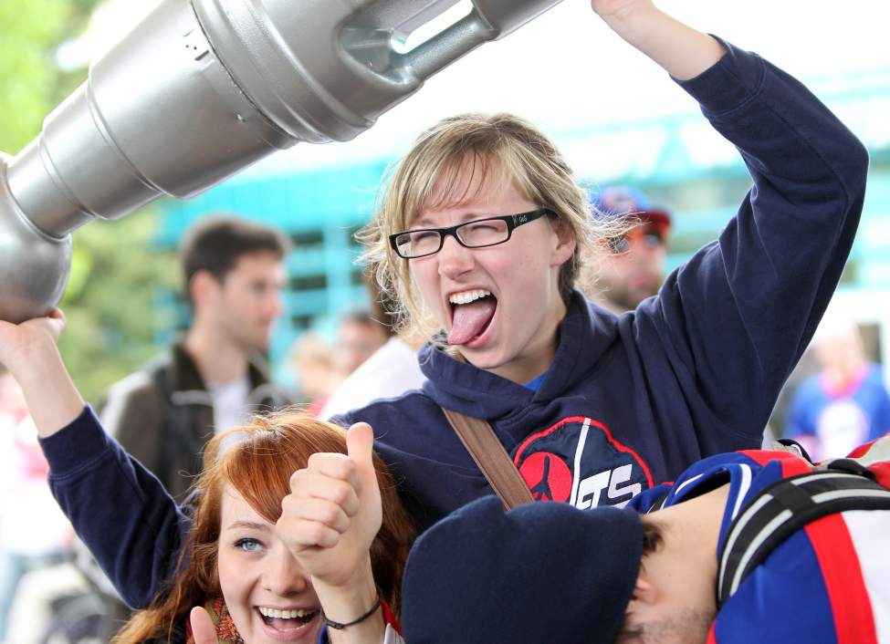Katerina Moore celebrates at the Forks lifting high a plastic Stanley Cup with friends Tuesday afternoon.
(RUTH BONNEVILLE/WINNIPEG FREE PRESS)