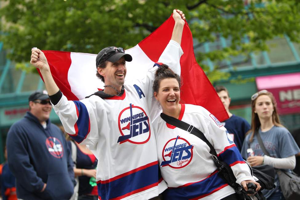 Paul and Kathy Vlamins celebrate with a Canadian flag at the Forks Tuesday afternoon.
(RUTH BONNEVILLE/WINNIPEG FREE PRESS)
