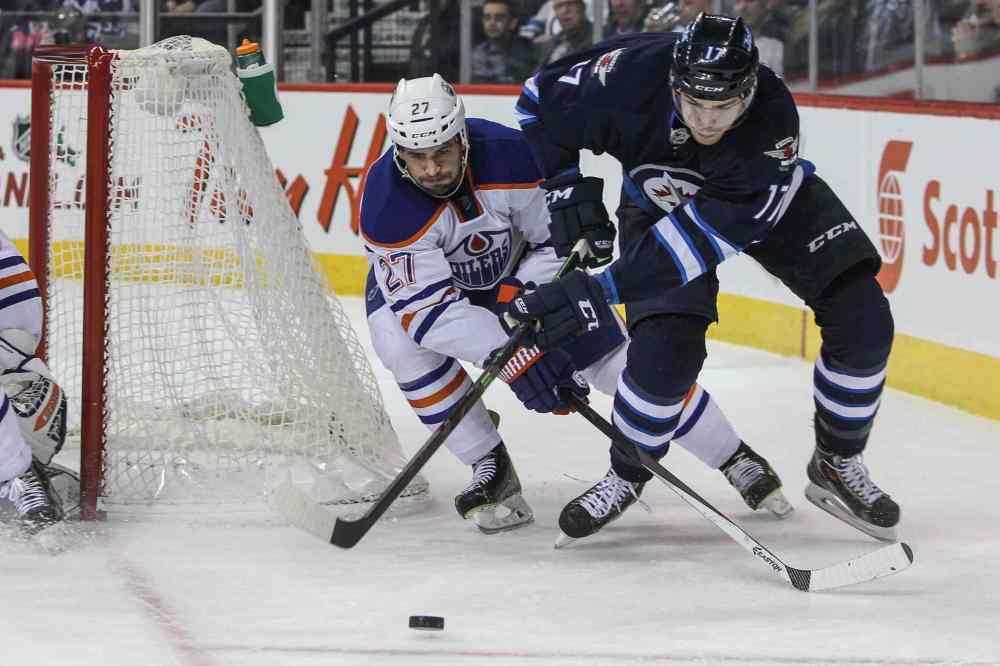 MIKE DEAL / WINNIPEG FREE PRESS
Winnipeg Jets' Adam Lowry (17) tries to get the puck around the Oilers' net while Edmonton Oilers' Boyd Gordon (27) checks him.