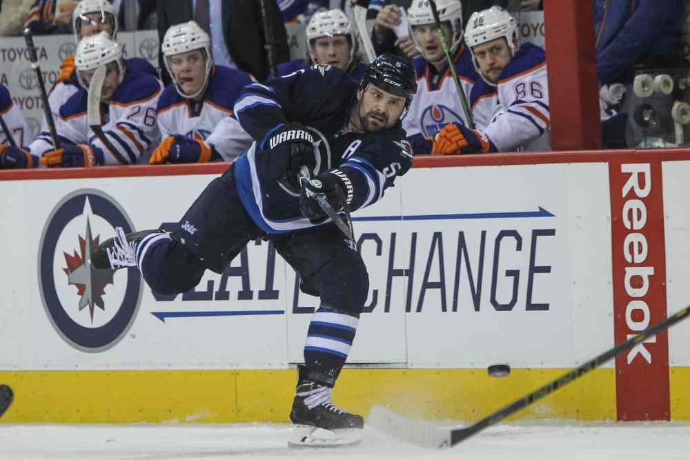 MIKE DEAL / WINNIPEG FREE PRESS
Winnipeg Jets Mark Stuart (5) fires the puck down the ice against the Edmonton Oilers.