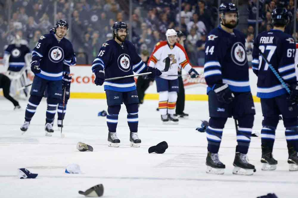 John Woods / Winnipeg Free Press
Winnipeg Jets' Mathieu Perreault (85) smiles as fans throw hats on the ice after the announcement of his hat trick against the Florida Panthers. The hat trick was closely followed by a fourth goal for Perreault.