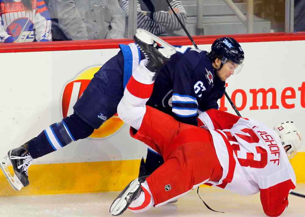 Boris Minkevich / Winnipeg Free Press
The Jets' Michael Frolik takes down Red Wings' Brian Lashoff during second period Thursday.
