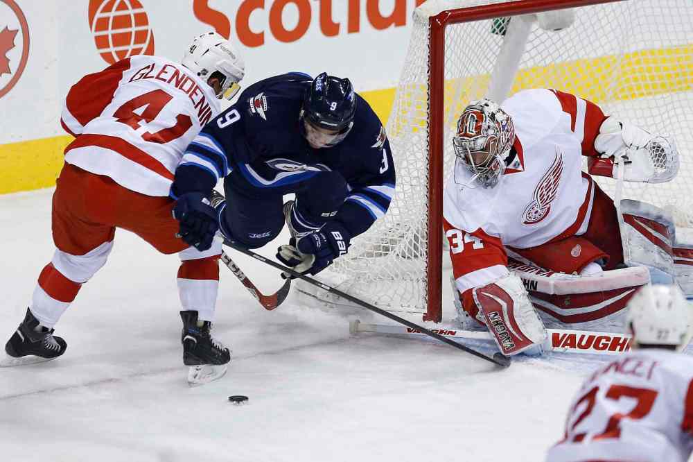 John Woods / The Canadian Press
Winnipeg Jets' Evander Kane (9) gets dumped by Detroit Red Wings' Luke Glendening (41) as goaltender Petr Mrazek (34) looks on during first period NHL action in Winnipeg on Thursday.