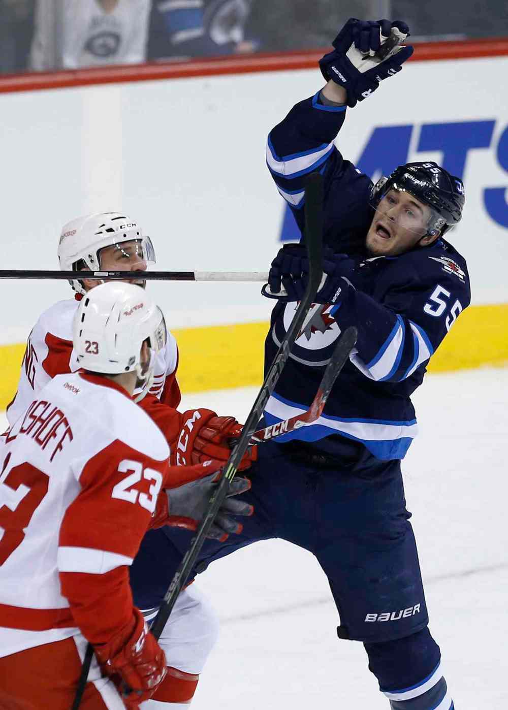 John Woods / The Canadian Press
Winnipeg Jets' Mark Scheifele (55) grabs the puck from in front of Detroit Red Wings' Brian Lashoff (23) and Luke Glendening (41) during the first period of Thursday's game.