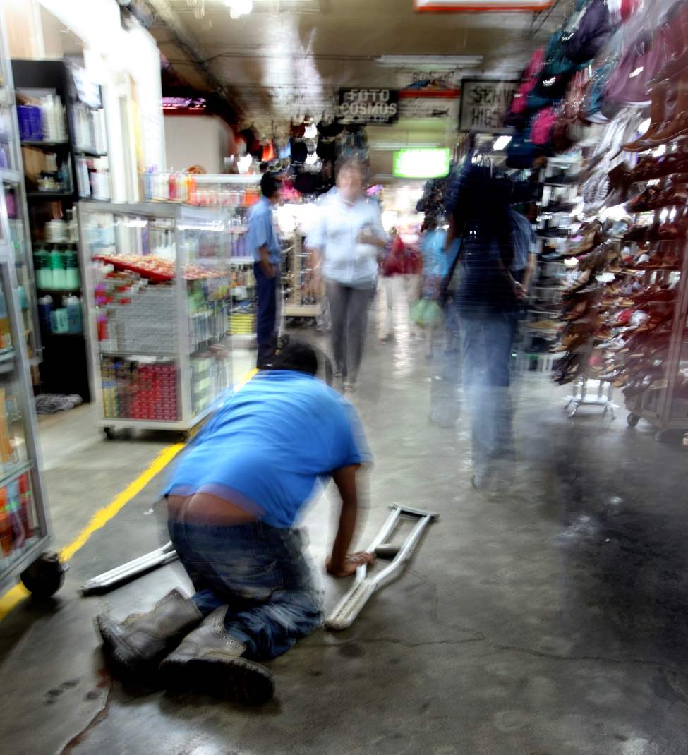 A badly crippled man makes his way on hands and knees through a Managua public market. Winnipeg's Operation Walk team arrived in the Nicaraguan Capitol to treat people like him who depend on their own mobility to survive in the central American country.