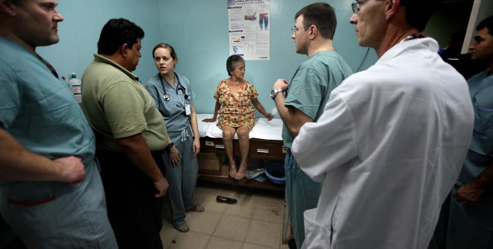 Maria Gomez is surrounded by specialists from the Operation Walk team for her assessment prior to surgery.