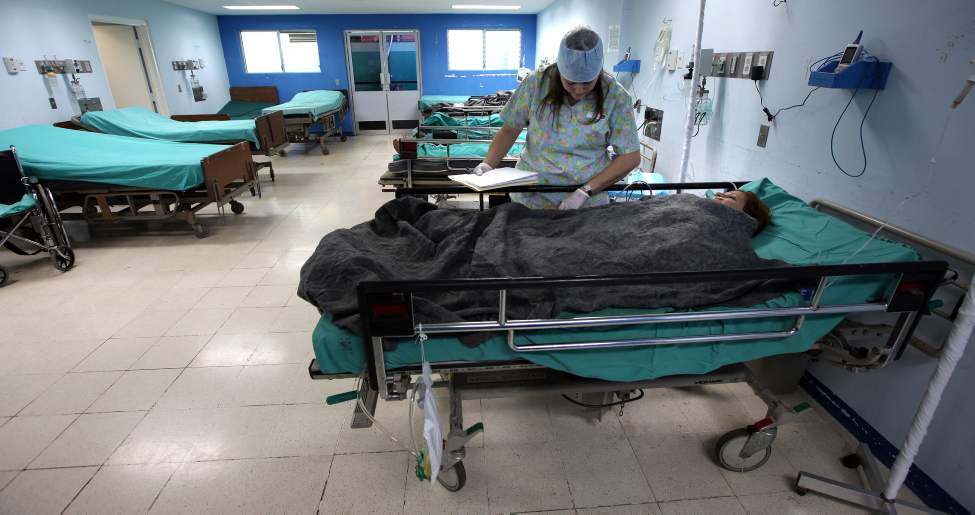 Surrounded by empty beds, Sylvia Vega recovers from surgery under the care of nurse Elaine Hassan.