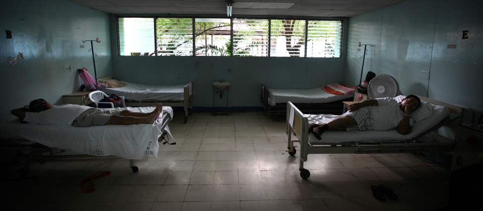 Patients wait on their beds for surgery in the men's ward.