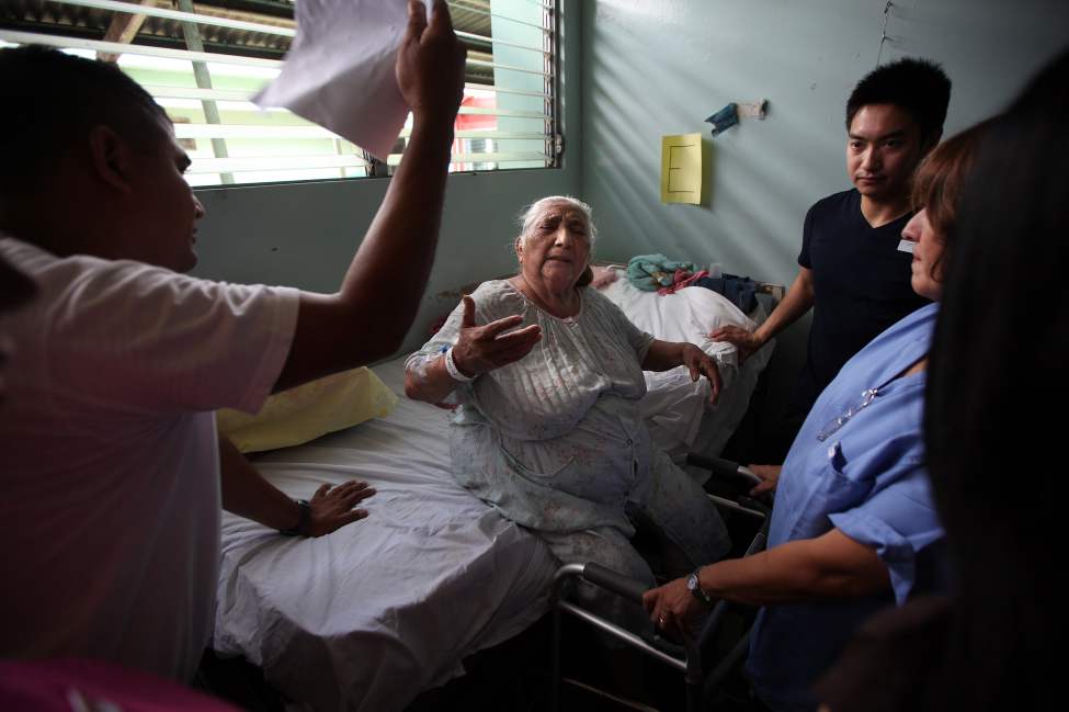 Suffering the heat poorly, Lucia Moyorga urges her son to fan her harder after a short walk the day following her surgery.