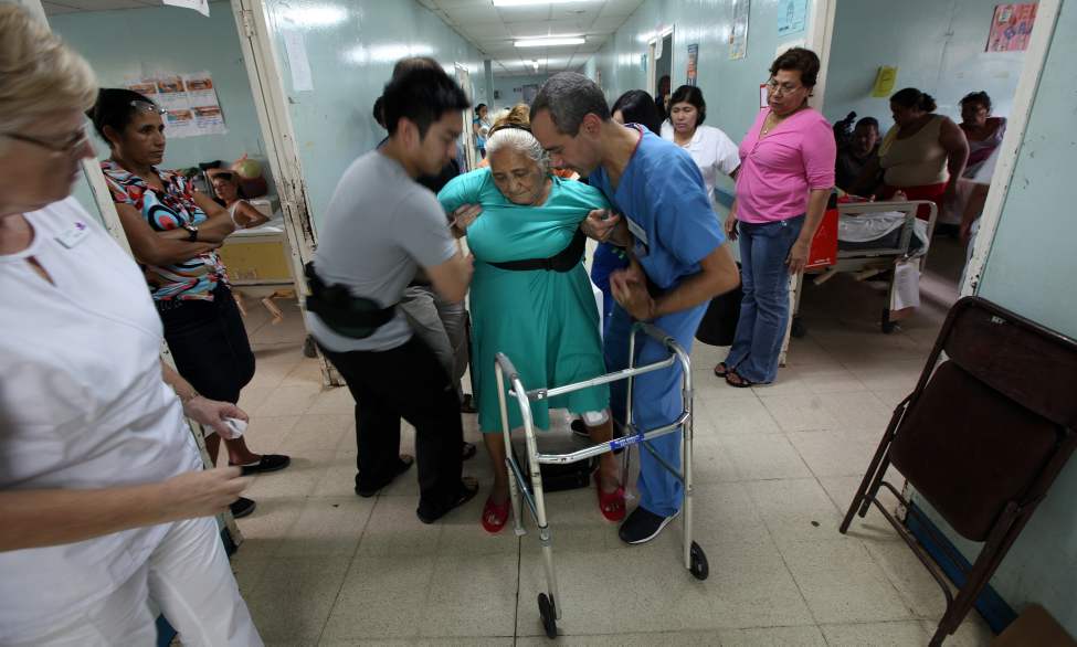 Lucia Moyorga is supported by Adian Salonga (left) and Victor Medina as she gets her feet underneath her for the first time following her surgery.