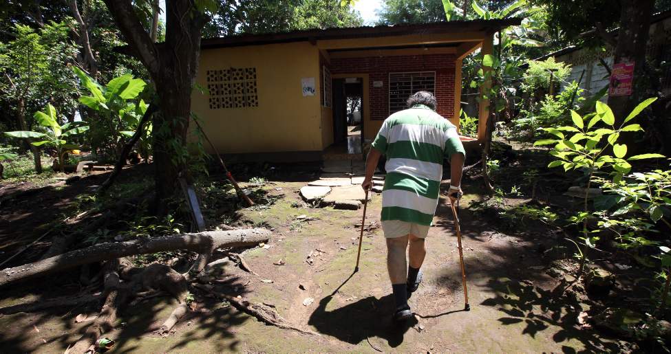 Juan Canada walks toward his home on the outskirts of Managua four days after surgery.