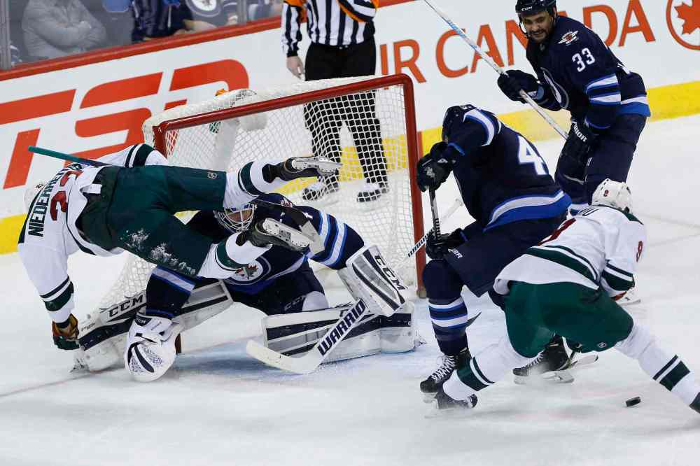 John Woods / Winnipeg Free Press
Minnesota Wild's Nino Niederreiter (22) flies across the crease of Winnipeg Jets goaltender Michael Hutchinson (34) as Jets' Zach Bogosian (44) and Wild's Mikko Koivu (9) look for the rebound and Jets' Dustin Byfuglien (33) looks on during first period.