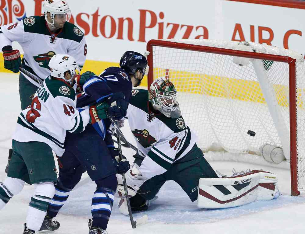 John Woods / Winnipeg Free Press
Minnesota Wild goaltender Devan Dubnyk (40) deflects the shot from Winnipeg Jets' Adam Lowry (17) as Wild's Jared Spurgeon (46) and Marco Scandella (6) defend during the first period of Tuesday's game in Winnipeg.