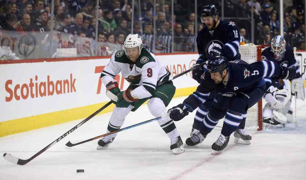 Trevor Hagan / The Canadian Press
Minnesota Wild's Mikko Koivu (9) skates to the puck as Winnipeg Jets' Bryan Little (18) and Mark Stuart (5) defend during the first period of Tuesday's game.