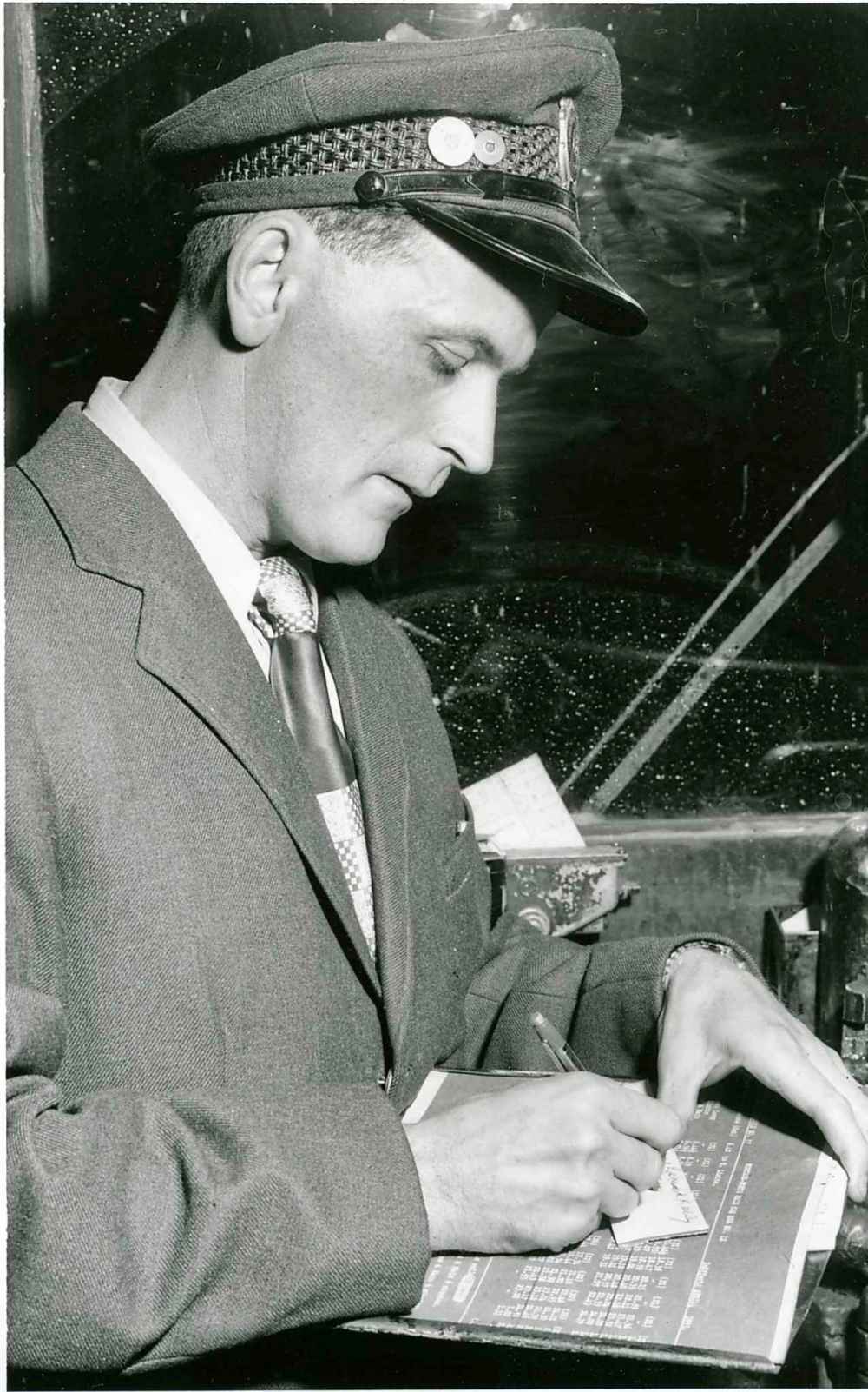 WINNIPEG FREE PRESS FILES
A streetcar conductor autographs transfers during last trip of streetcar he was operating on Sept. 21, 1955.