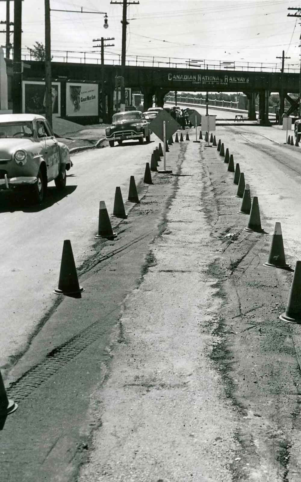 WINNIPEG FREE PRESS FILES
The streetcar link between Winnipeg and St. Vital disappears as construction crews remove the rails in July 1952. St. Vital was the first Greater Winnipeg municipality affected by the Winnipeg Electric company's oust-the-trams plan. Clearance work began July 1 when gasoline buses took over the job of commuting St. Vital citizens to and from Winnipeg. This picture shows the approach to the Norwood Bridge as it appeared after workers had removed the tracks.