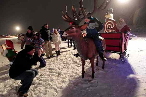 Phil Hossack / Winnipeg Free PressFamilies line up to snap a shot with Santa and Rudolf at the Canad Inns Winter Wonderland at the Red River Exhibition Park Tuesday night.