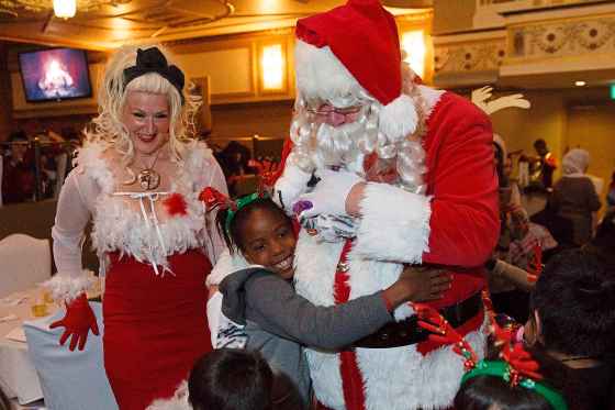 Obehi Okihira, a Grade 2 student at Lavallee School, gives Santa a big hug at Variety Manitoba's Winter Wonderland children's party at the Metropolitan Entertainment Centre on Monday, Dec.10. The children were served lunch were entertained by holiday tunes and magicians, and met Santa and Mrs. Claus.