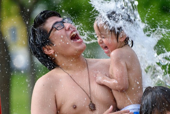 JESSE BOILY  / WINNIPEG FREE PRESSJason McDonald, 3, and Dremond Bunn cool off at the Machray park spray pad on Monday.