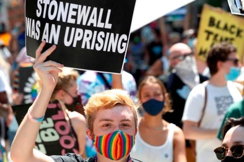 FILE - A person holds up a sign referencing the Stonewall Inn, during a queer liberation march for Black Lives Matter and against police brutality, Sunday, June 28, 2020, in New York. Parades celebrating LGBTQ pride kick off in some of America's biggest cities Sunday amid new fears about the potential erosion of freedoms won through decades of activism. The annual marches in New York, San Francisco, Chicago and elsewhere take place just two days after one conservative justice on the Supreme Court signaled, in a ruling on abortion, that the court should reconsider the right to same-sex marriage recognized in 2015. (AP Photo/Kathy Willens, File)