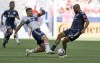 Vancouver Whitecaps' Lucas Cavallini, left, tries to push the the ball past New England Revolution's Andrew Farrell during first half MLS soccer action in Vancouver, B.C., Sunday, June 26, 2022. THE CANADIAN PRESS/Rich Lam