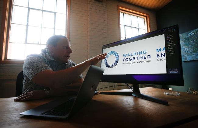 Shaun Vincent, creative director of Vincent Design, looks at the papal visit logo in his design studio in Winnipeg, Monday, June 27, 2022. Vincent has designed the logo and branding materials for the upcoming papal visit. THE CANADIAN PRESS/John Woods