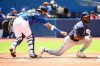 Tampa Bay Rays batter Randy Arozarena, right, is tagged out by Toronto Blue Jays catcher Gabriel Moreno after a dropped third strike in first inning American League baseball action in Toronto, Sunday, July 3, 2022. THE CANADIAN PRESS/Jon Blacker