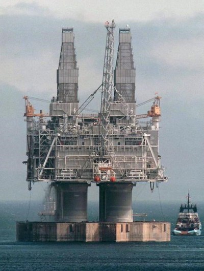 A tugboat positions itself near the base of the Hibernia platform in Bull Arm, Trinity Bay, N.L., Thursday, May 22, 1997. Newfoundland and Labrador's offshore oil regulator has laid charges in connection with a 2019 oil spill in the Hibernia field, which sits about 315 kilometres off the coast of St. John's. THE CANADIAN PRESS/Jonathan Hayward
