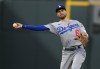 Los Angeles Dodgers shortstop Trea Turner thorws to first base to put out Colorado Rockies' Yonathan Daza during the third inning of a baseball game Wednesday, June 29, 2022, in Denver. (AP Photo/David Zalubowski)