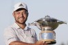 Xander Schauffele holds the trophy after winning the Genesis Scottish Open at The Renaissance Club, North Berwick, Scotland, Sunday July 10, 2022. (Steve Welsh/PA via AP)