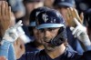 Kansas City Royals' Whit Merrifield celebrates in the dugout after hitting a two-run home run during the eighth inning of a baseball game against the Cleveland Guardians Friday, July 8, 2022, in Kansas City, Mo. (AP Photo/Charlie Riedel)
