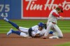 Toronto Blue Jays centre fielder George Springer (4) steals second base during first inning interleague MLB action against the Philadelphia Phillies second baseman Bryson Stott (5) in Toronto on Tuesday, July 12, 2022. CANADIAN PRESS/Christopher Katsarov