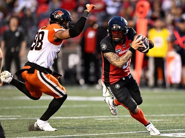 Ottawa Redblacks quarterback Jeremiah Masoli (8) dodges past BC Lions defensive end Obum Gwacham (98) during first half CFL football action in Ottawa on Thursday, June 30, 2022. THE CANADIAN PRESS/Justin Tang