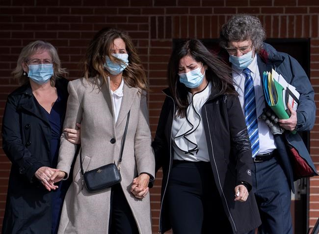 Lisa Banfield, second from left, spouse of Gabriel Wortman, is escorted by friends along with lawyer James Lockyer, right, as they leave Nova Scotia provincial court in Dartmouth, N.S., on Wednesday, March 9, 2022. The lawyer for the wife of the man responsible for the worst mass shooting in modern Canadian history says she is apprehensive about her appearance Friday before a public inquiry. THE CANADIAN PRESS/Andrew Vaughan