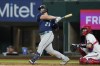 Seattle Mariners' Ty France follows through on a two-run single next to Texas Rangers catcher Jonah Heim during the eighth inning of a baseball game Thursday, July 14, 2022, in Arlington, Texas. (AP Photo/Tony Gutierrez)