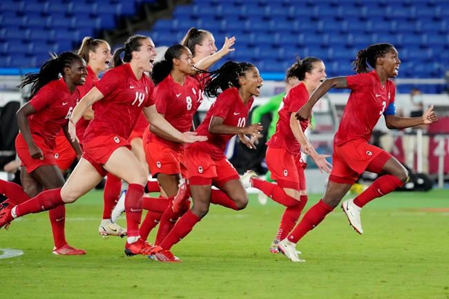 Canada players run onto the field after defeating Sweden in the penalty shootout in the women's soccer final during the summer Tokyo Olympics in Yokohama, Japan on Friday, August 6, 2021. THE CANADIAN PRESS/Frank Gunn