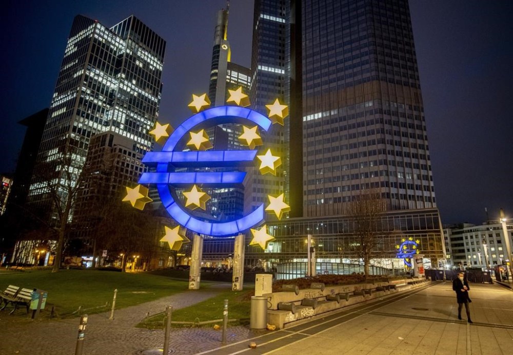 FILE - A man walks past the Euro sculpture in Frankfurt, Germany, March 11, 2021. The European Central Bank is behind the U.S. Federal Reserve and other central banks around the world in combating surging inflation. It’s looking to catch up as it raises interest rates for the first time in 11 years Thursday July 21, 2022, but it also faces a more serious threat of recession than other places amid an energy crisis provoked by Russia’s war in Ukraine. (AP Photo/Michael Probst, File)