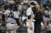 New York Yankees relief pitcher Michael King, center, is tended to by a trainer during the eighth inning of a baseball game against the Baltimore Orioles, Friday, July 22, 2022, in Baltimore. King left the game with an injury. New York Yankees catcher Jose Trevino is at left. The Yankees won 7-6. (AP Photo/Nick Wass)