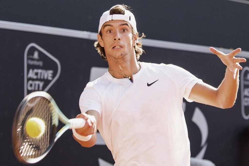 Italy's Lorenzo Musetti returns the ball to Spain's Carlos Alcaraz, during the final match of the Hamburg tennis tournament, Germany, Sunday July 24, 2022. (Daniel Bockwoldt/dpa via AP)