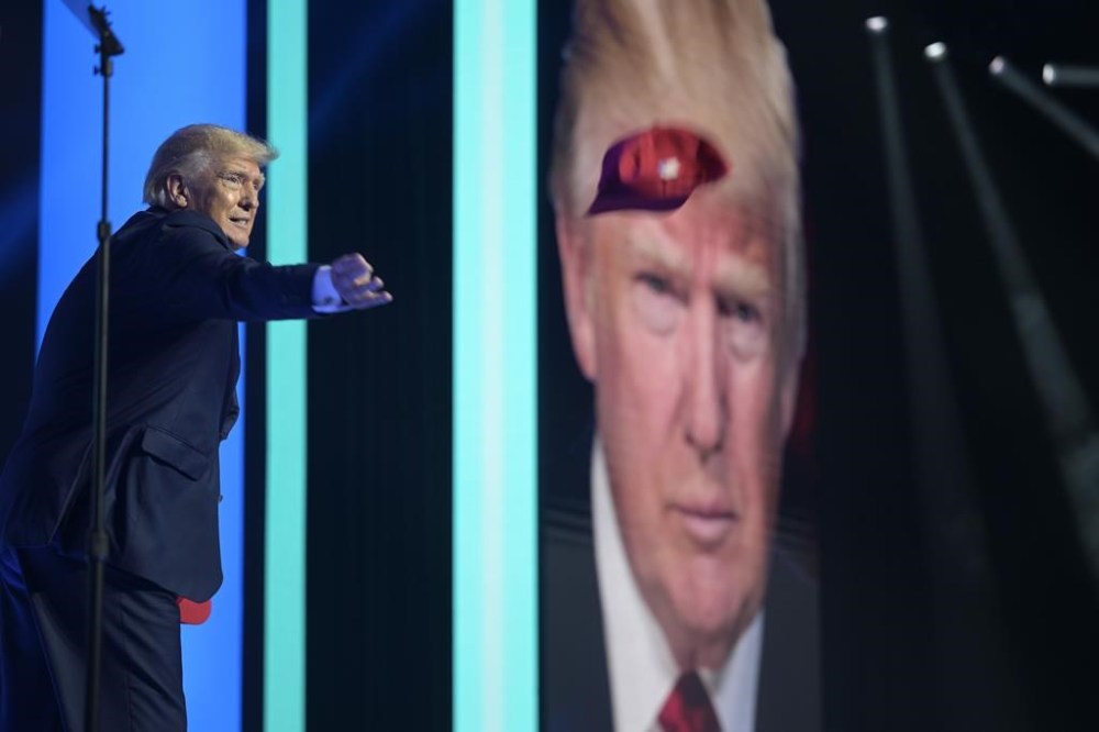 Former President Donald Trump tosses hats into the crowd before addressing attendees during the Turning Point USA Student Action Summit, Saturday, July 23, 2022, in Tampa, Fla. (AP Photo/Phelan M. Ebenhack)