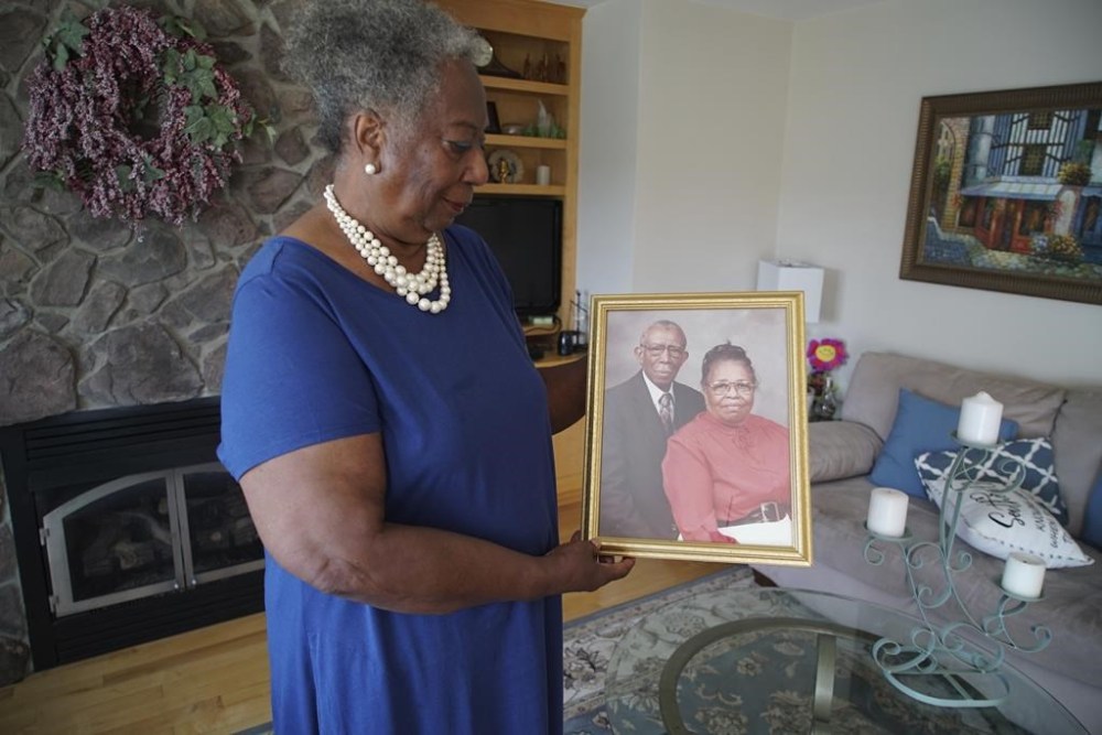 Lillie Tyson Head holds a photograph of her late parents, Freddie Lee and Johnnie Mae Neal Tyson, at her home in Wirtz, Va., on Saturday, July 23, 2022. Freddie Tyson was part of the infamous