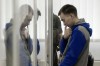 Russian army Sergeant Vadim Shishimarin, 21, is seen behind a glass during a court hearing in Kyiv, Ukraine, Monday, July 25, 2022. Kyiv Appeal court has started to consider an appeal on a life sentence for Shishimarin after he was sentenced for the killing of a 62-year-old man who was shot in the head in a village in the northeastern Sumy region in the opening days of the war. (AP Photo/Danylo Antoniuk)