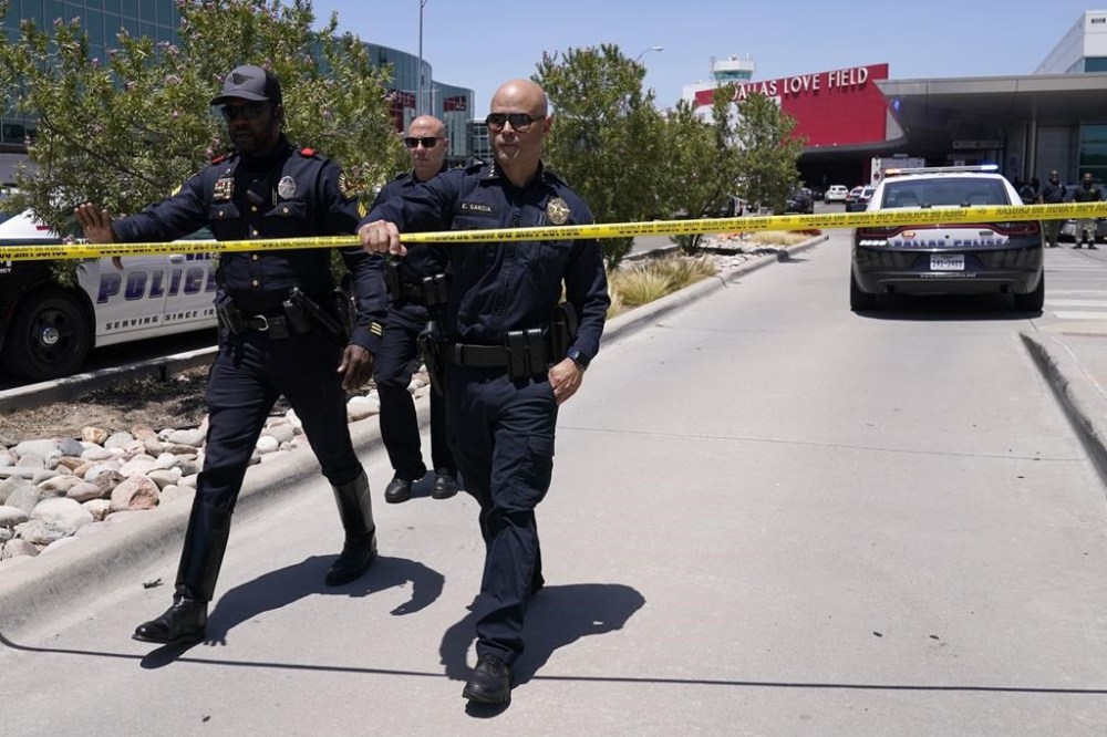 Dallas Chief of Police, Edgardo Garcia, right, and two other officers depart Dallas Love Field in Dallas, Monday, July 25, 2022 A 37-year-old woman fired several gunshots, apparently at the ceiling, inside of Dallas' Love Field Airport on Monday before an officer shot and wounded her, authorities said. (AP Photo/Tony Gutierrez)