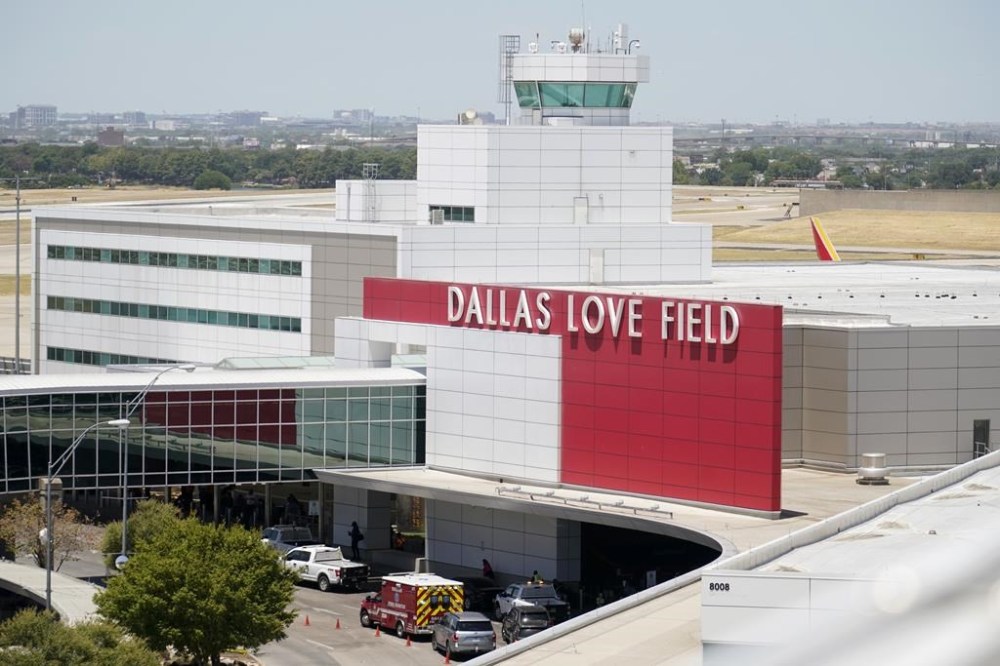 Emergency responders are shown near the main entrance at Dallas Love Field in Dallas, Monday, July 25, 2022.  A 37-year-old woman fired several gunshots, apparently at the ceiling, inside of Dallas' Love Field Airport on Monday before an officer shot and wounded her, authorities said. (AP Photo/Tony Gutierrez)
