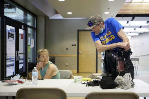 Rory Lidster, 55, right, and Amanda Marshall, 41, unpack after checking into a cooling center in Portland, Ore., Tuesday, July 26, 2022. Temperatures are expected to top 100 degrees F (37.8 C) on Tuesday and wide swaths of western Oregon and Washington are predicted to be well above historic averages throughout the week. 