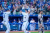 Toronto Blue Jays' Matt Chapman (26) celebrates with Lourdes Gurriel Jr. (13) as Detroit Tigers catcher Eric Haase (13) looks on after Chapman hit a two-run home run during fourth inning AL MLB baseball action, in Toronto on Thursday, July 28, 2022. THE CANADIAN PRESS/Christopher Katsarov