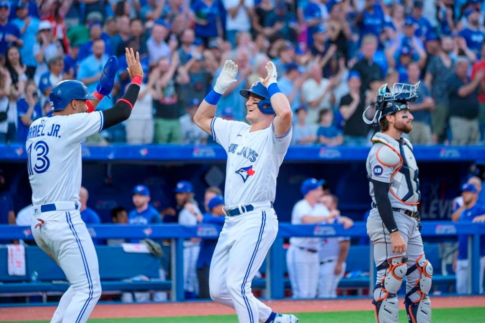 Toronto Blue Jays' Matt Chapman (26) celebrates with Lourdes Gurriel Jr. (13) as Detroit Tigers catcher Eric Haase (13) looks on after Chapman hit a two-run home run during fourth inning AL MLB baseball action, in Toronto on Thursday, July 28, 2022. THE CANADIAN PRESS/Christopher Katsarov