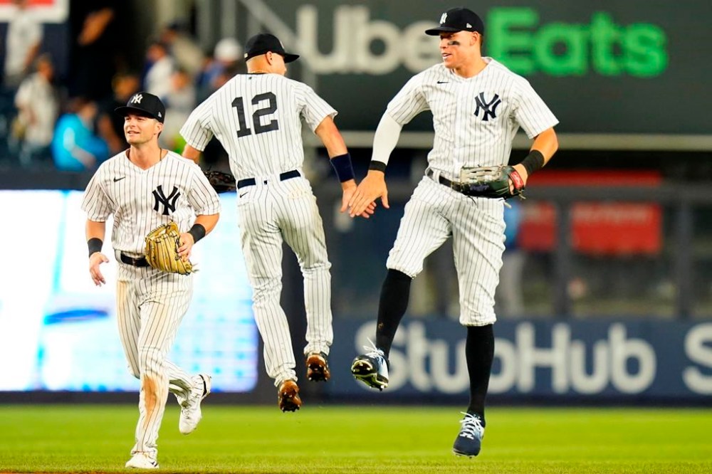New York Yankees' Andrew Benintendi, left, Isiah Kiner-Falefa, center, and Aaron Judge celebrate after a baseball game against the Kansas City Royals, Friday, July 29, 2022, in New York. The Yankees won 11-5. (AP Photo/Frank Franklin II)