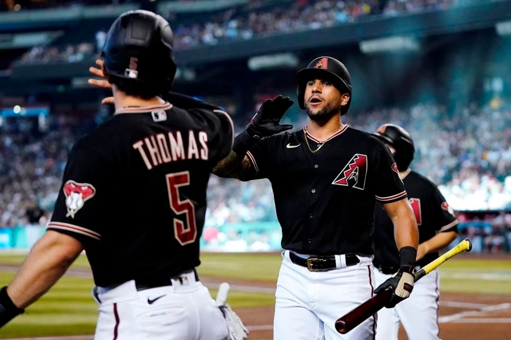 Arizona Diamondbacks' Alek Thomas (5) celebrates his run scored against the Washington Nationals with David Peralta, right, during the first inning of a baseball game Saturday, July 23, 2022, in Phoenix. (AP Photo/Ross D. Franklin)