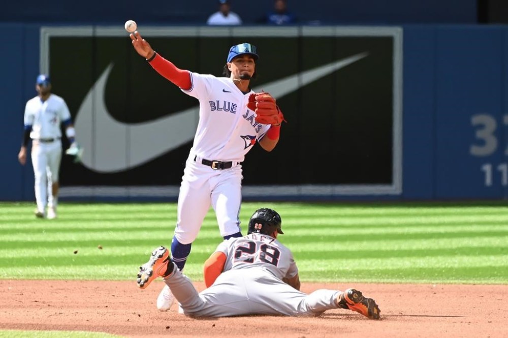 Toronto Blue Jays second baseman Santiago Espinal, top, throws to first base to put out Detroit Tigers' Miguel Cabrera after forcing out Javier Baez at second base in the fourth inning of American League baseball action in Toronto, Saturday, July 30, 2022. THE CANADIAN PRESS/Jon Blacker